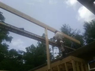 Carpenter setting a ridge beam over a new addition frame — Ice Dam Removal by Roofing Brothers in Shelly