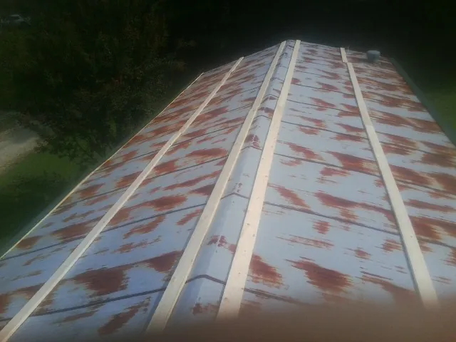 Rusted metal roof panels with new wood purlins before replacement — Storm Damage Roof Repair in Shelly by Roofing Brothers