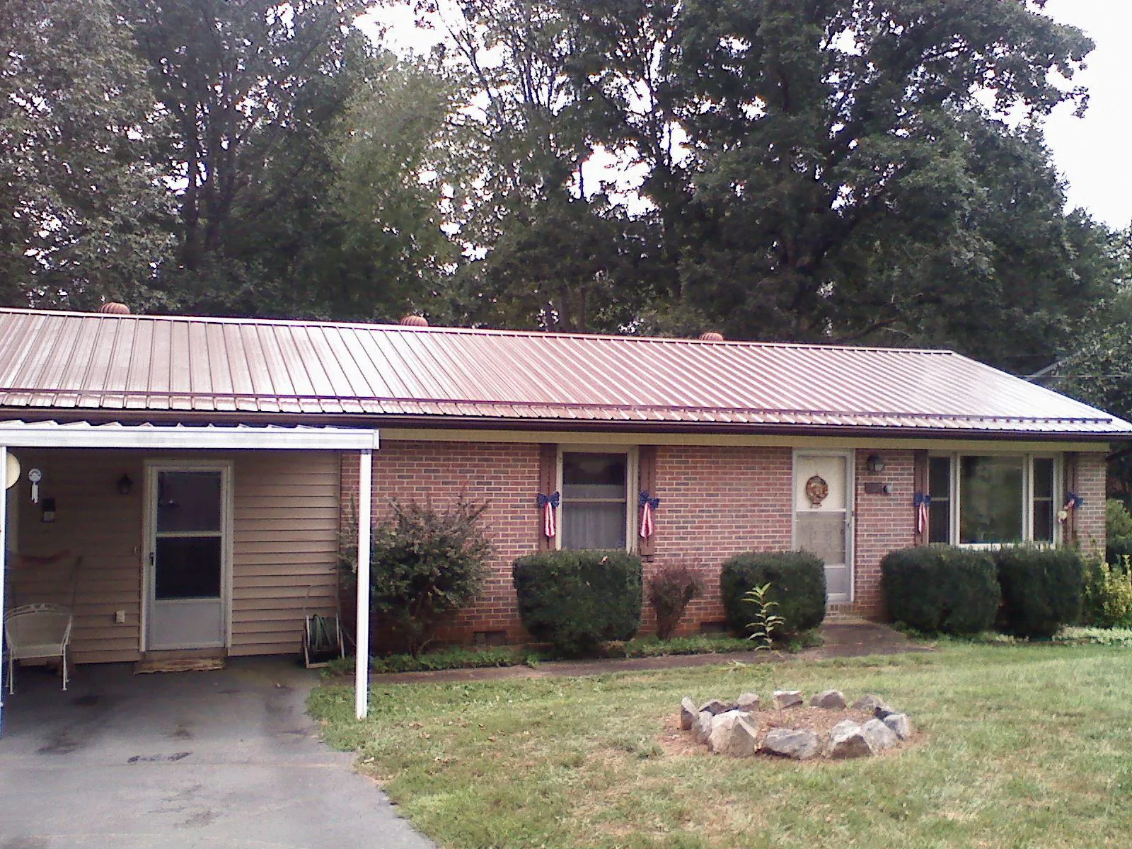 Bronze metal roof and carport on a brick ranch home — Roof Repair work by our crew in Shelly